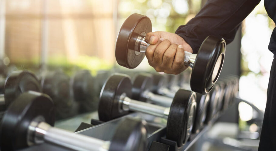 young fitness man with dumbbell gym weight training exercise gym lifting dumbbell bodybuilder good health