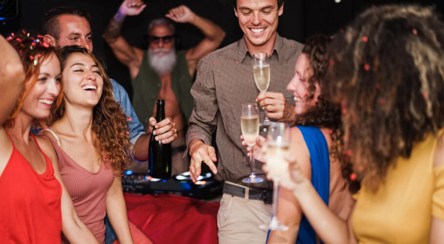 young multicultural friends dancing at house party with man in center