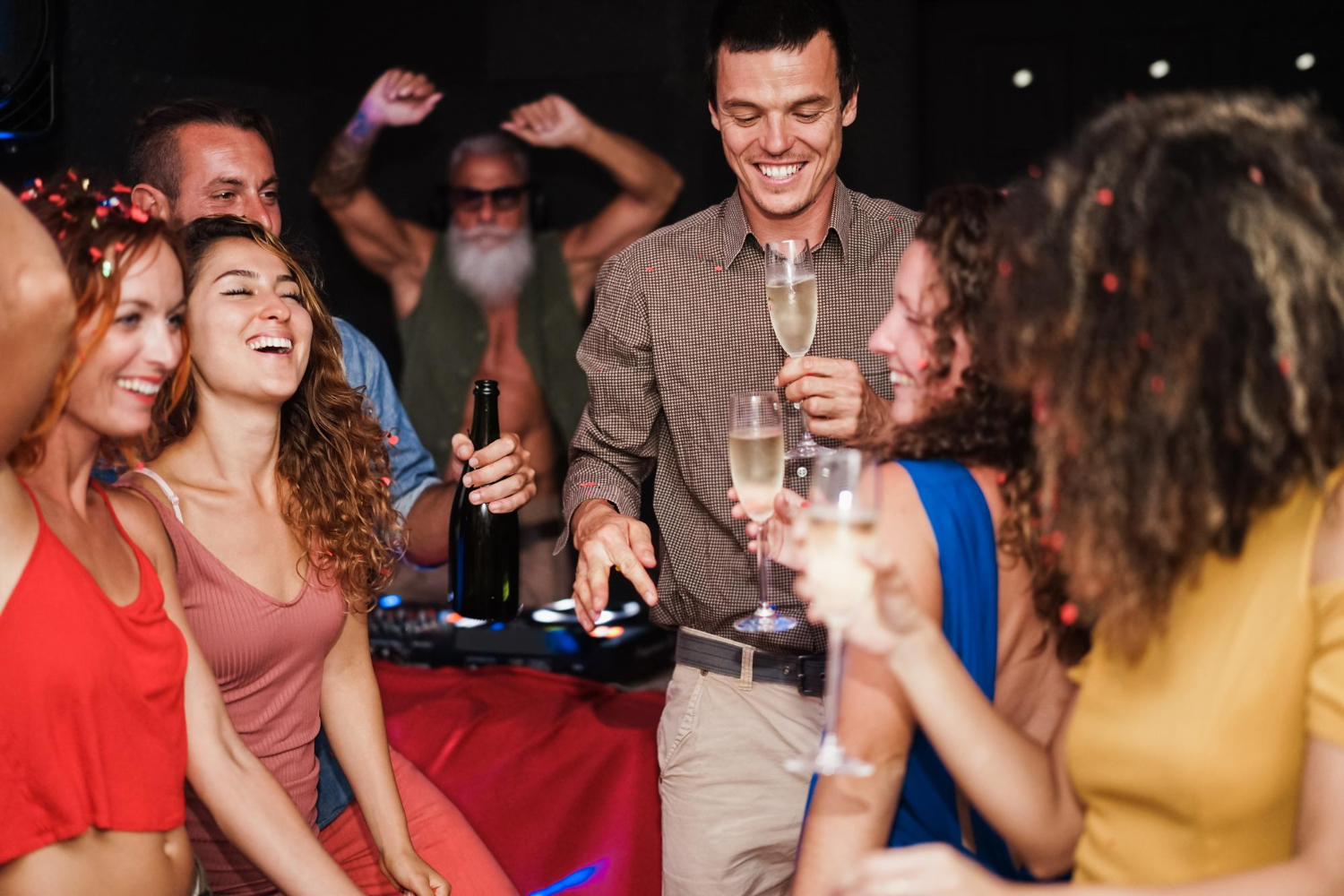 young multicultural friends dancing at house party with man in center