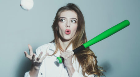 young pretty woman cute sexy girl with beautiful long hair red lips adorable surprised face holds green baseball bat racket ball