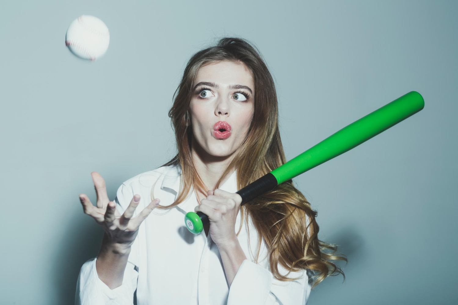 young pretty woman cute sexy girl with beautiful long hair red lips adorable surprised face holds green baseball bat racket ball