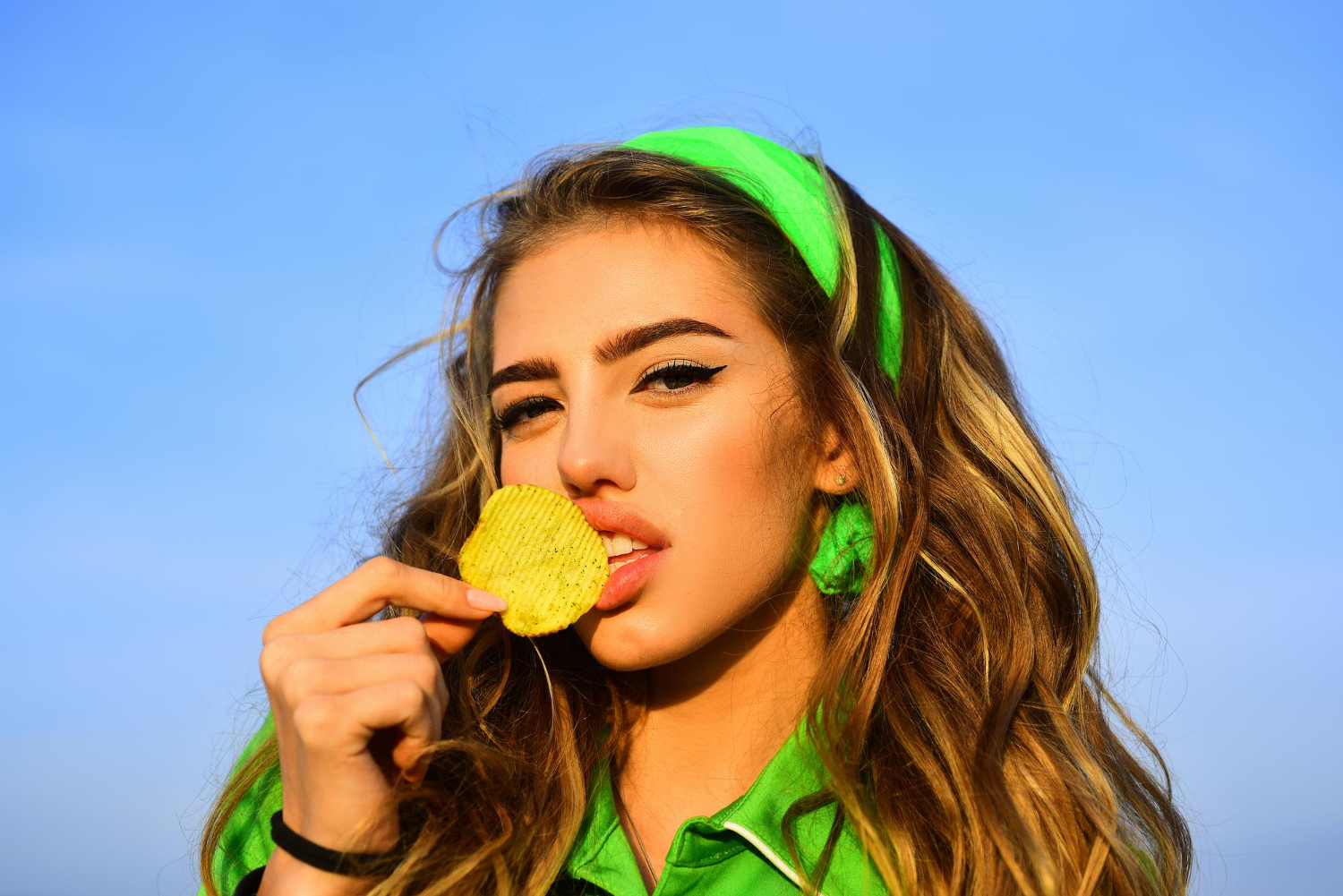 young woman beautiful lips bright makeup holding eating fried potato fries chips posing pretty woman